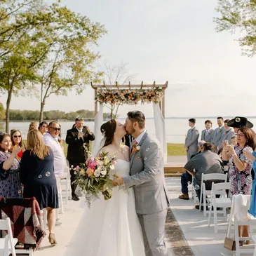 Dallas wedding venue near Corsicana. Couple kissing after the wedding ceremony by the lake. Romantic wedding venue, wedding venue on water.