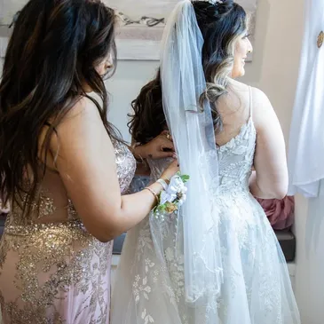 Mother of the bride zipping up the wedding dress at a wedding venue near Dallas. East Texas wedding venue, intimate wedding venue, large bride suite for getting ready.