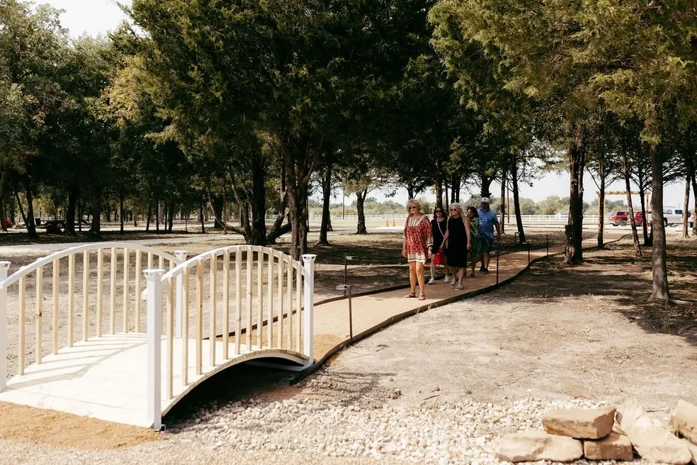 Wedding venue guests walking towards a bridge.