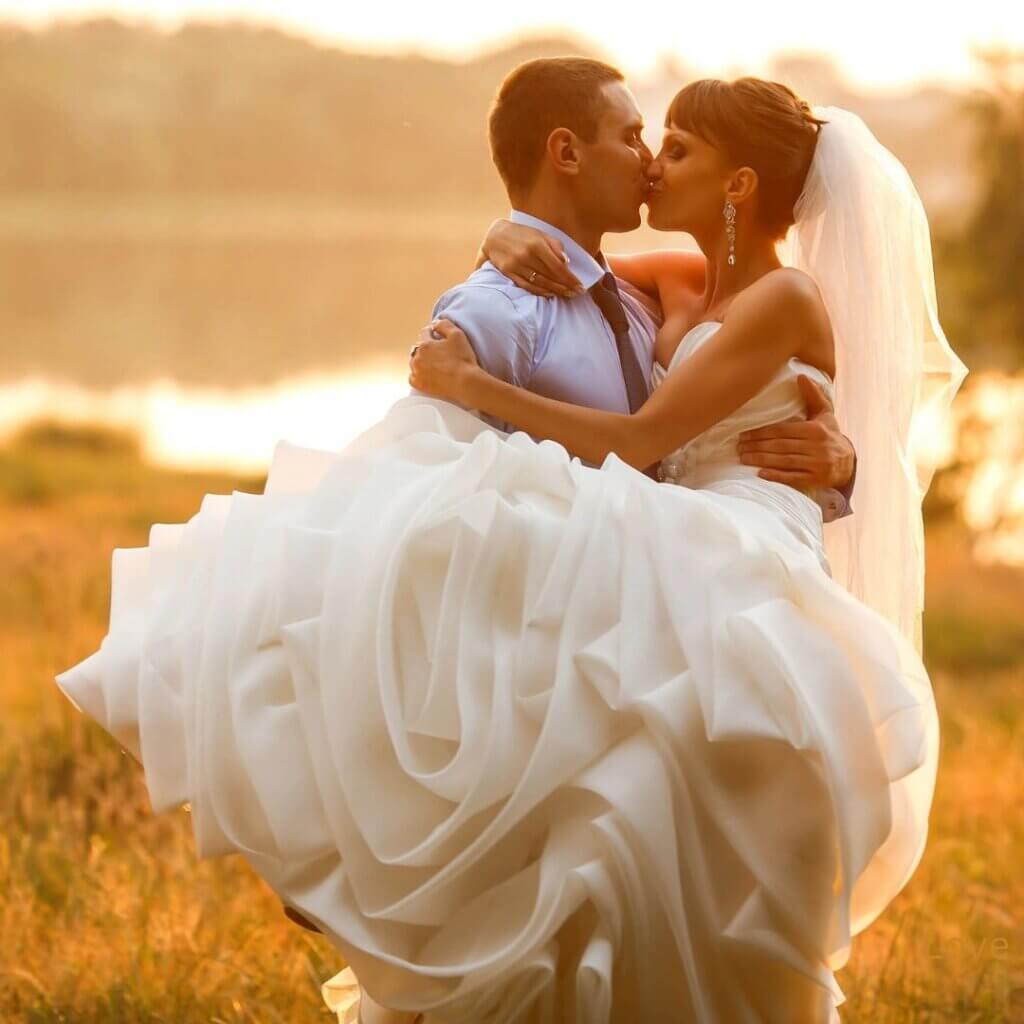 Bride and Groom kissing by the lake shore. Romantic wedding venue near Dallas.
