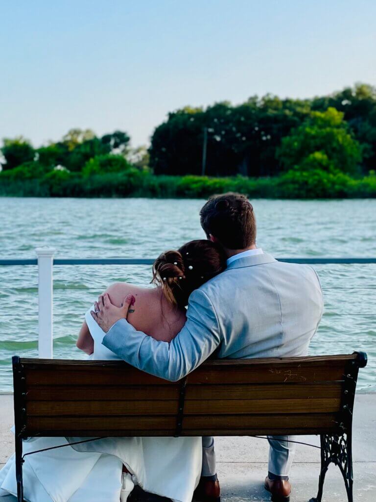 Bride and groom enjoying quiet lakefront moment during their North Texas wedding weekend.
