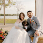 Bride and groom celebrating outdoors during sunset at a lakeside wedding venue while planning their wedding timeline and checklist for the big day.