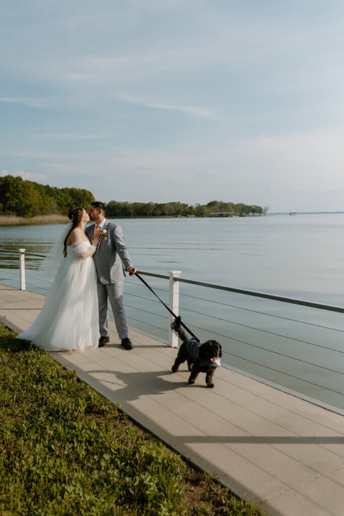Bride and groom walking along the water at Lakefront Acres waterfront wedding venue in North Texas.