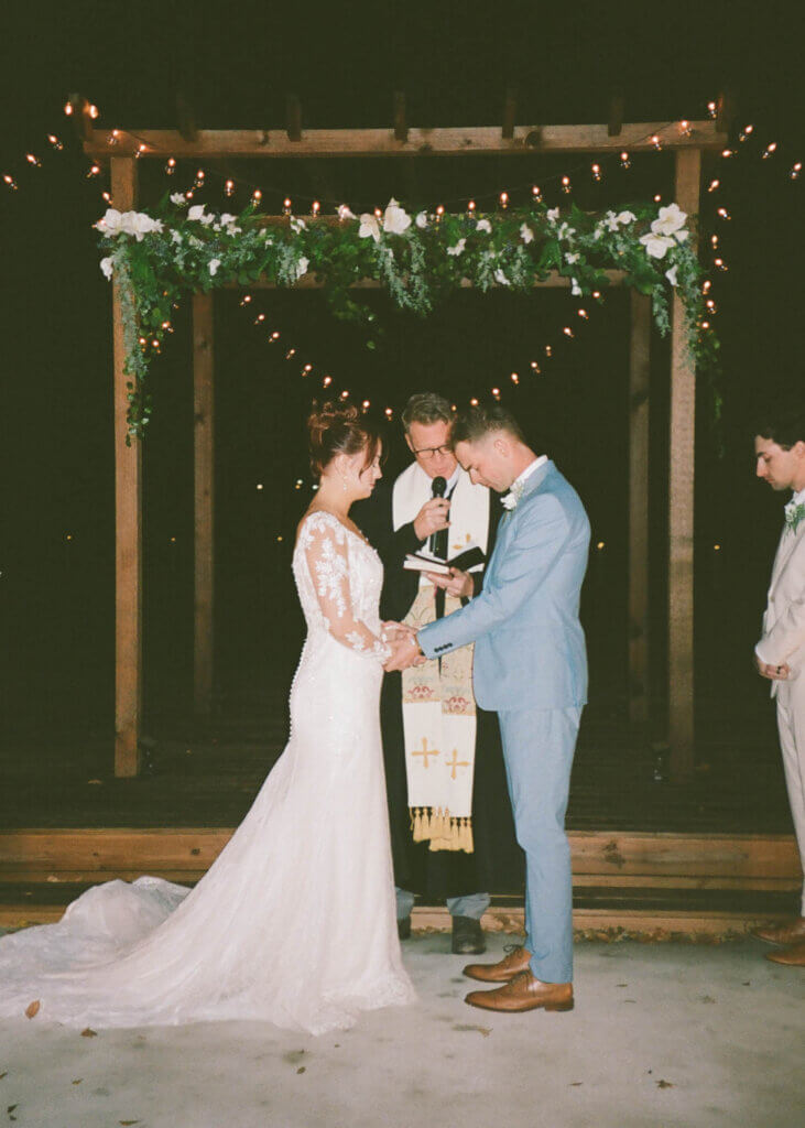 Bride and groom praying together at Lakefront Acres wedding venue in Corsicana Texas