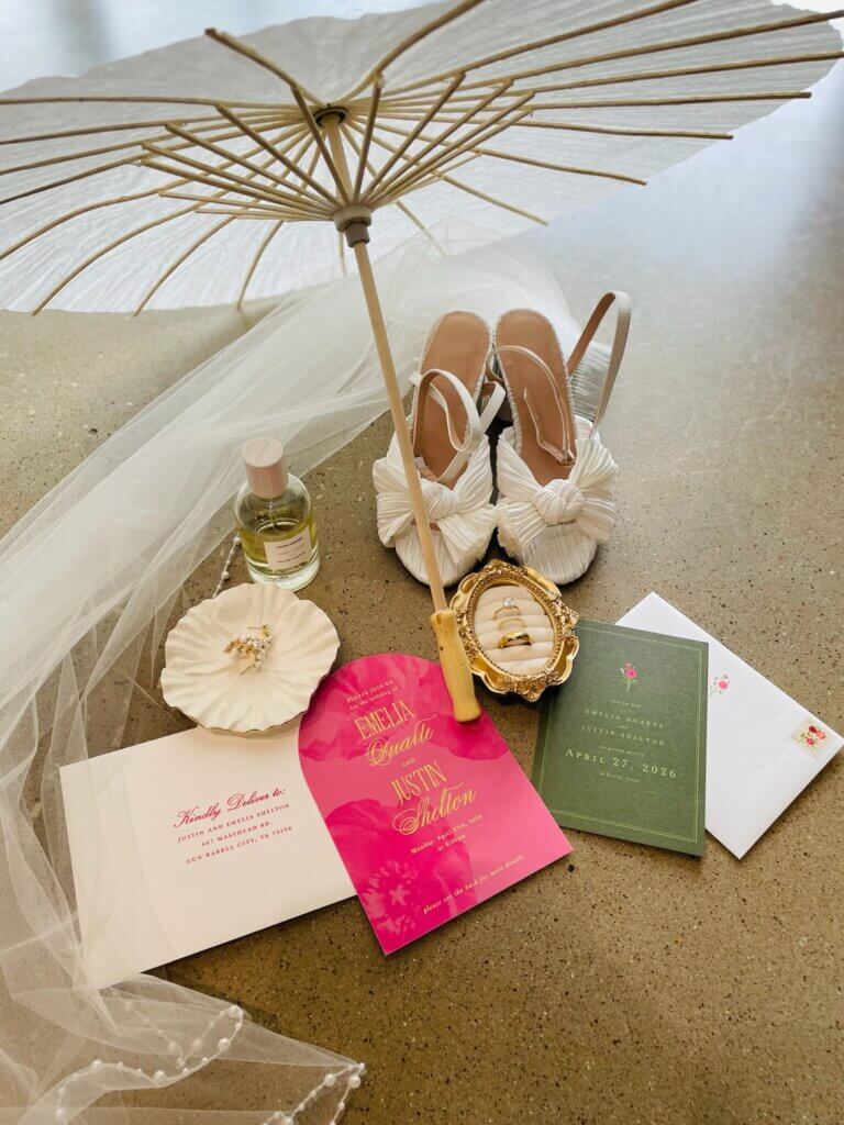 Wedding flat lay featuring invitations, rings, timeline checklist, and bridal accessories for wedding planning inspiration