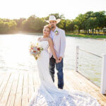 Bride and groom taking golden hour sunset wedding photos on the dock at Lakefront Acres Wedding & Event Venue