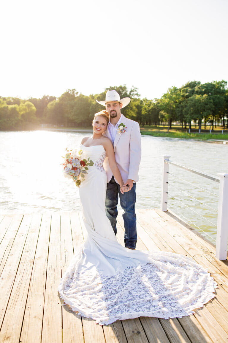 Bride and groom taking golden hour sunset wedding photos on the dock at Lakefront Acres Wedding & Event Venue